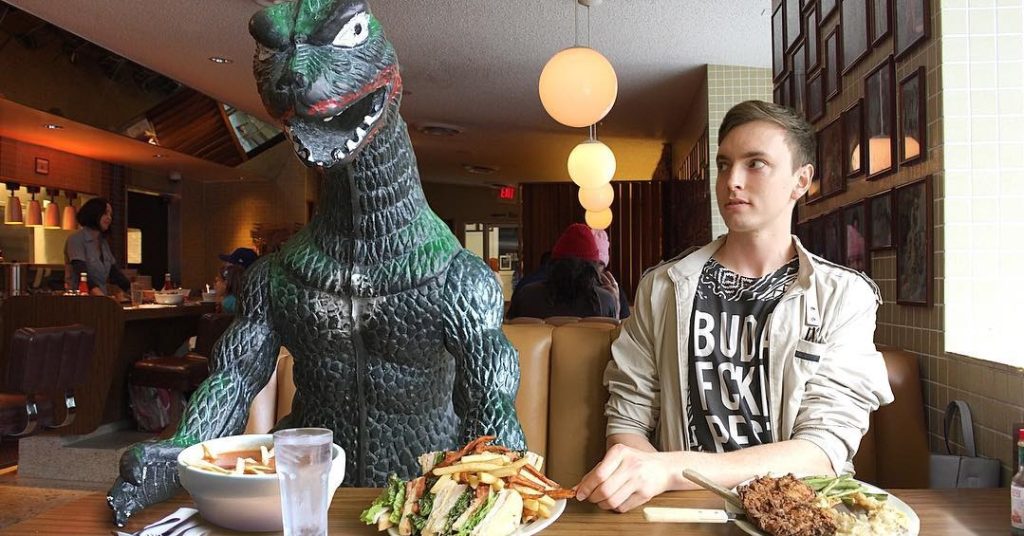 O homem que leva seu boneco de Godzilla em todas as viagens