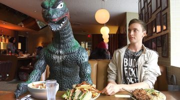 O homem que leva seu boneco de Godzilla em todas as viagens