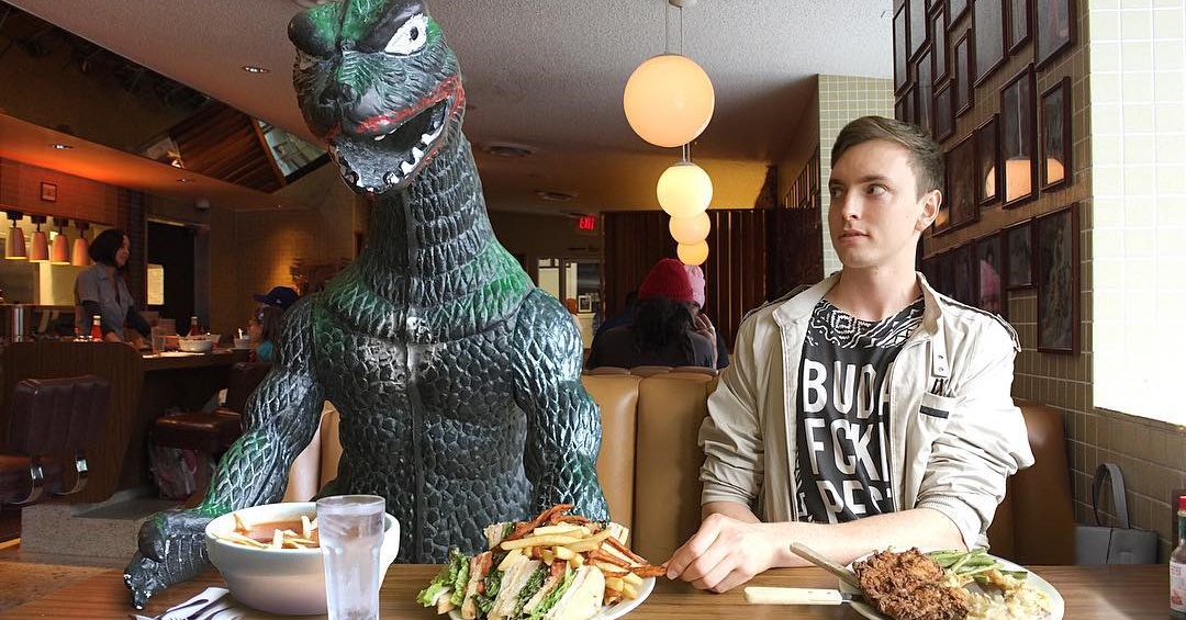 O homem que leva seu boneco de Godzilla em todas as viagens